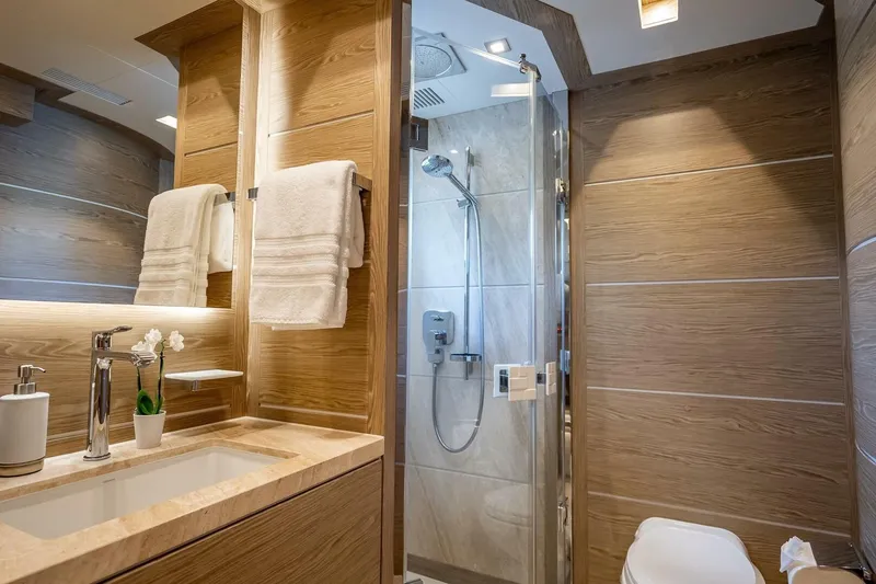 Slide: The Image of Luxurious yacht bathroom with wood accents, modern fixtures, and glass shower in Horizon RP120, 2017. - 48