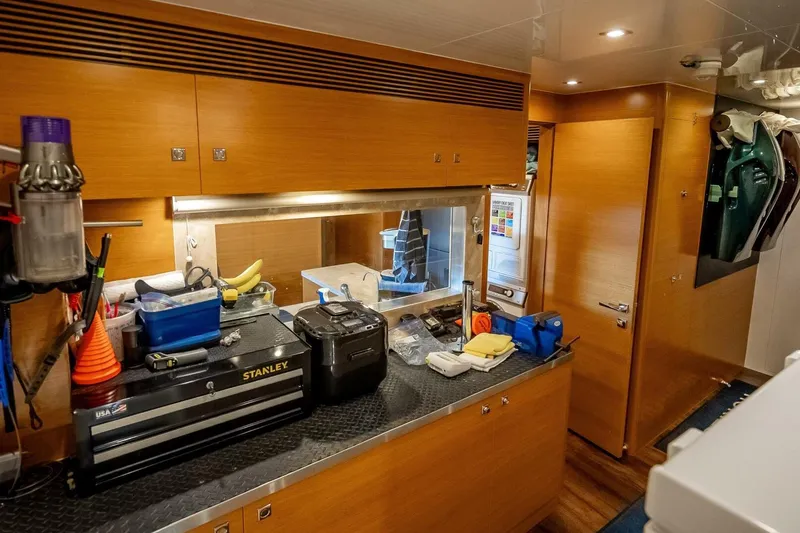 Slide: The Image of Laundry room in 2017 Horizon RP120 yacht with wooden cabinets and various tools. - 73