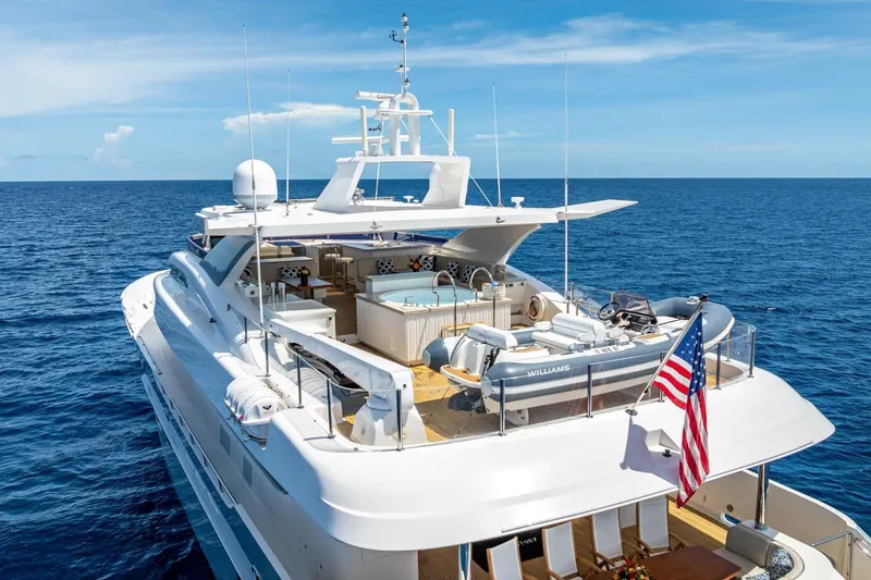 Slide: The Image of Luxurious 2017 Horizon RP120 yacht on open sea, featuring spacious deck and American flag. - 85