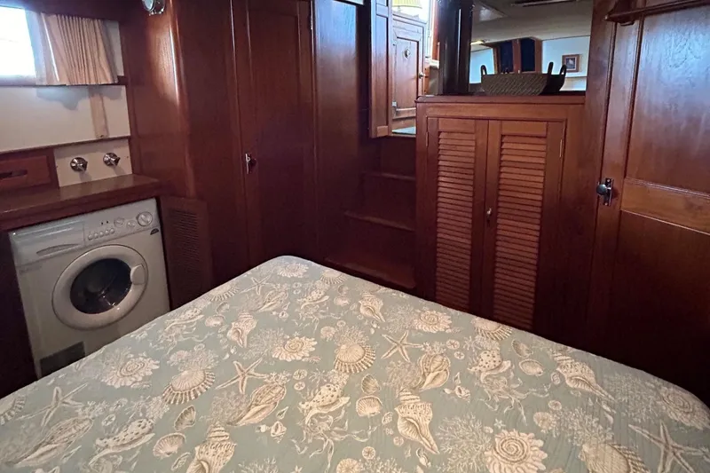 Slide: The Image of 1985 Grand Banks 42 Classic cabin with bed, washer, and wooden cabinetry. - 15