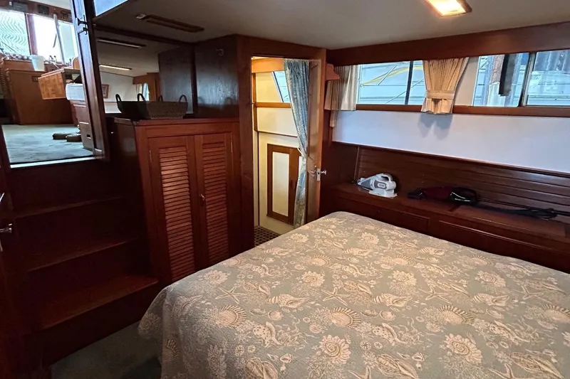 Slide: The Image of 1985 Grand Banks 42 Classic interior cabin with bed, wooden furnishings, and natural light. - 18