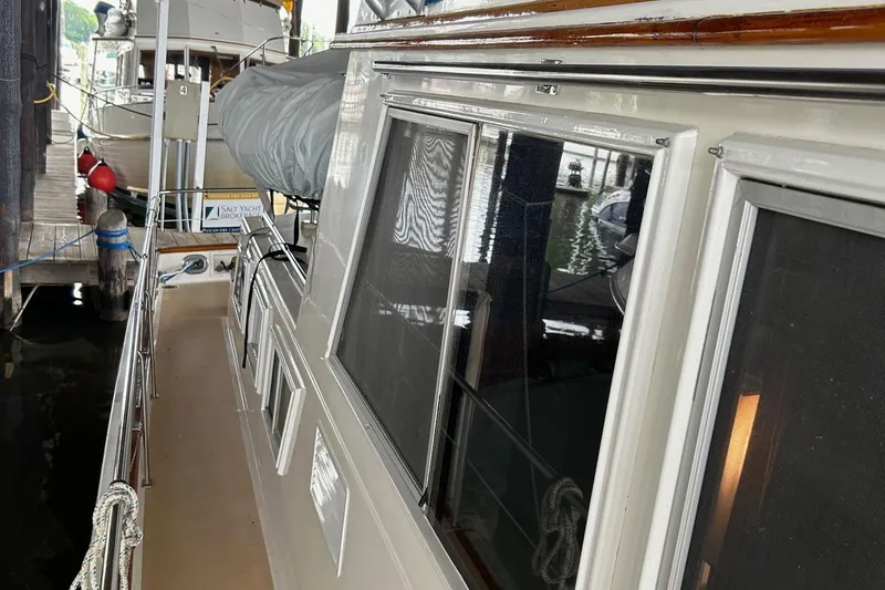 Slide: The Image of 1985 Grand Banks 42 Classic yacht docked, showcasing side deck and windows. - 2