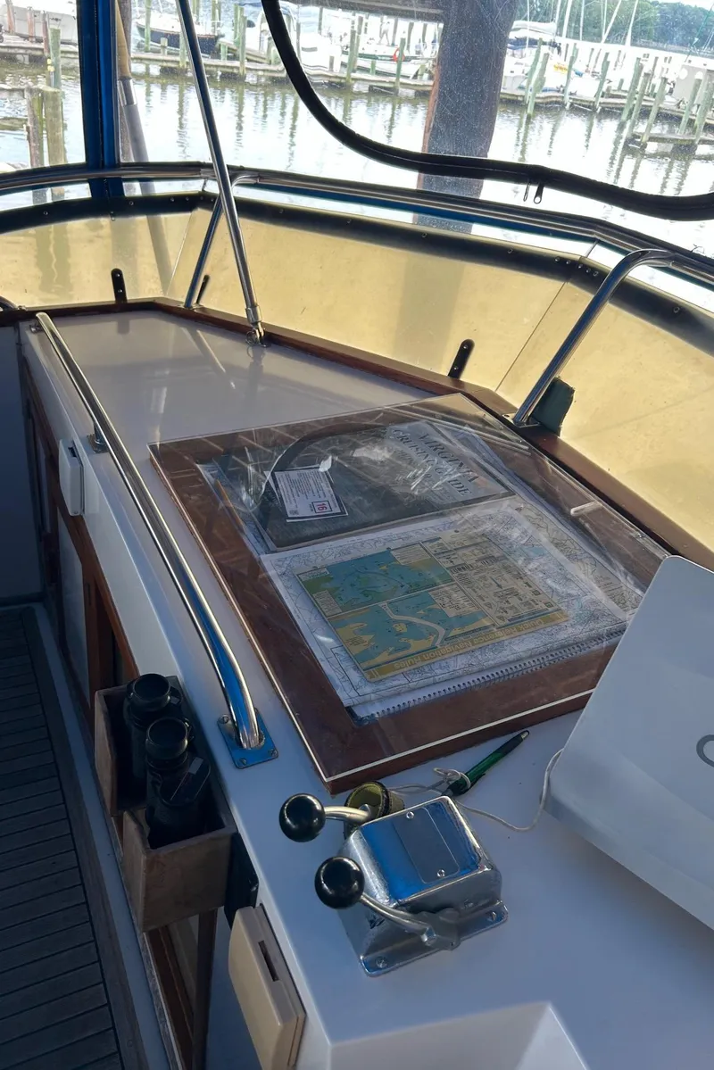 Slide: The Image of Navigation station on a 1985 Grand Banks 42 Classic yacht with maps and controls. - 27