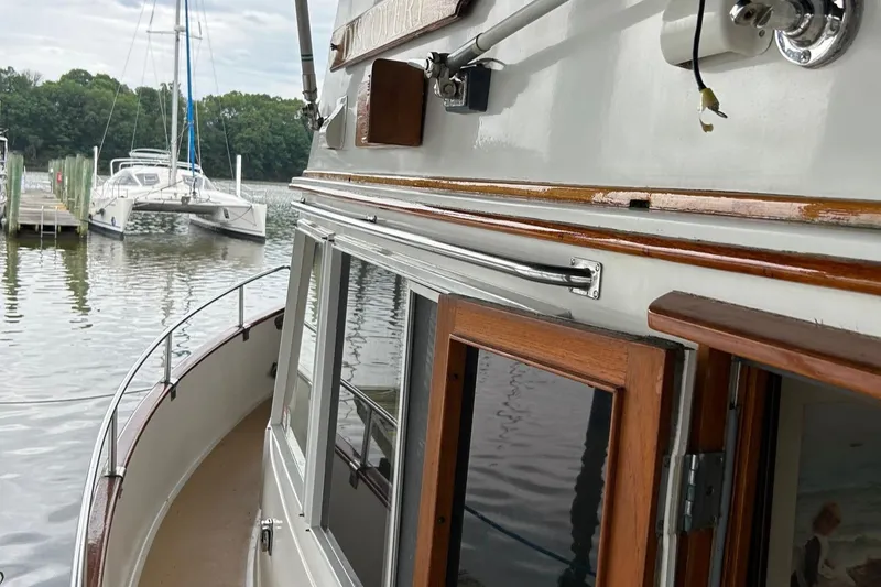 Slide: The Image of 1985 Grand Banks 42 Classic yacht docked at a marina, showcasing its elegant wooden details. - 28
