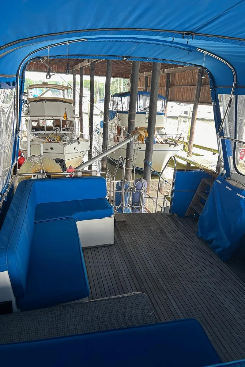 Slide: The Image of 1985 Grand Banks 42 Classic yacht interior with blue seating and dock view. - 29