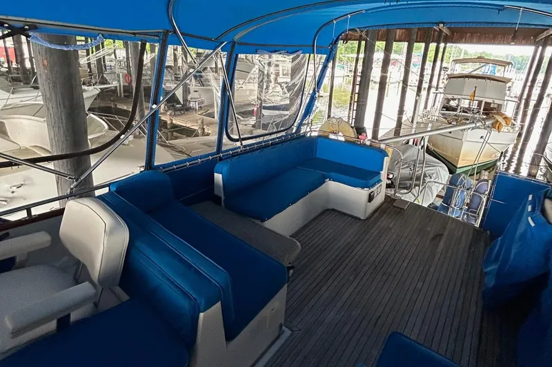 Slide: The Image of 1985 Grand Banks 42 Classic yacht interior with blue seating and wooden deck. - 31