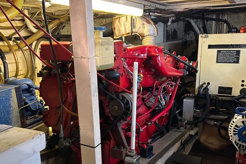 Slide: The Image of Engine room of a 1985 Grand Banks 42 Classic yacht, featuring a red engine. - 33