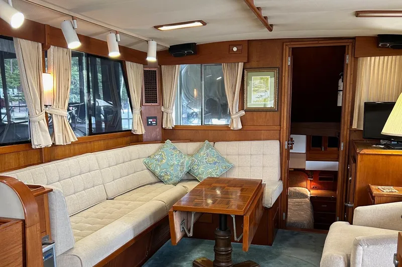 Slide: The Image of 1985 Grand Banks 42 Classic yacht interior with cozy seating and wooden furnishings. - 9