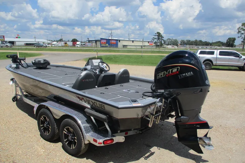 Slide: The Image of 2026 Vexus AVX1980 boat with Yamaha engine, parked on a trailer under a cloudy sky. - 2