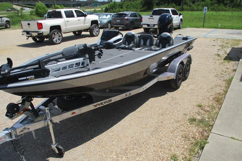 Slide: The Image of 2026 Vexus AVX1980 boat on trailer in parking lot, surrounded by vehicles. - 5