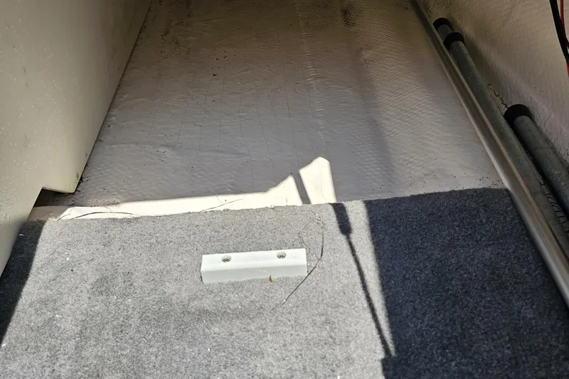 Slide: The Image of Interior view of a 2007 Regal 2000 Bowrider boat, showing carpeted flooring. - 100