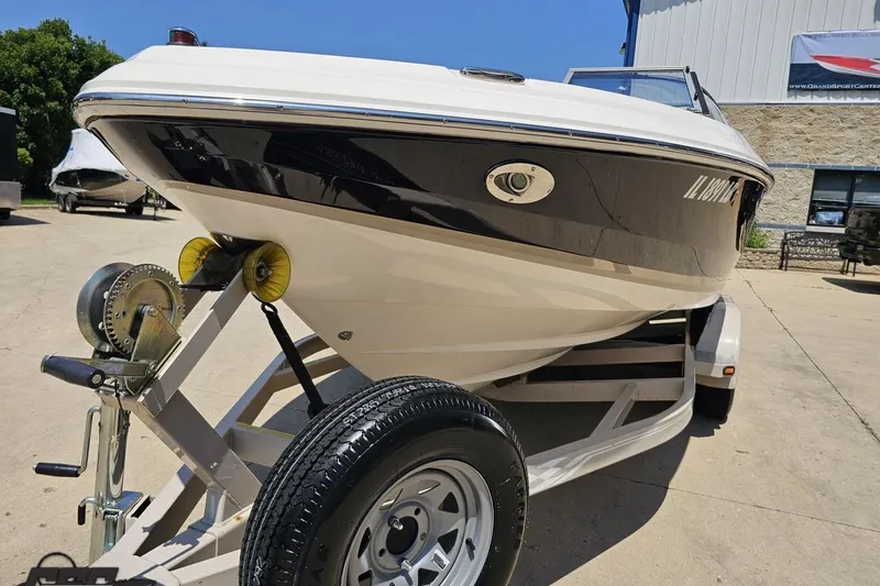 Slide: The Image of 2007 Regal 2000 Bowrider boat on trailer, parked outdoors under clear blue sky. - 13