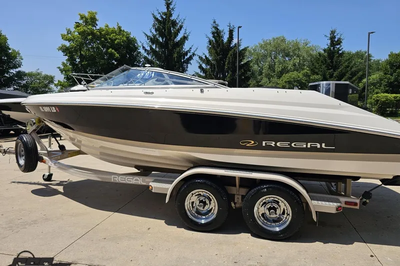 Slide: The Image of 2007 Regal 2000 Bowrider boat on trailer, parked outdoors on a sunny day. - 23