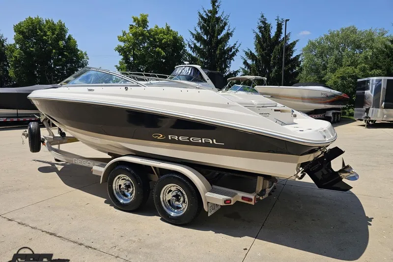 Slide: The Image of 2007 Regal 2000 Bowrider boat on trailer, parked outdoors on a sunny day. - 24