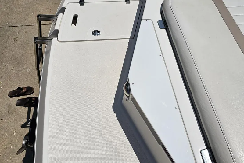 Slide: The Image of 2007 Regal 2000 Bowrider boat deck with seating and sandals nearby. - 40
