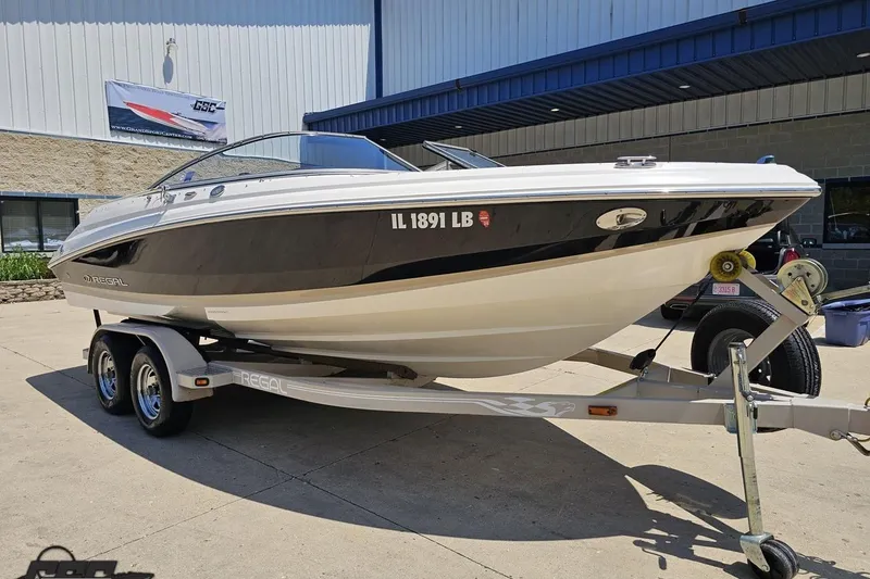 Slide: The Image of 2007 Regal 2000 Bowrider boat on trailer, parked outside a building. - 8