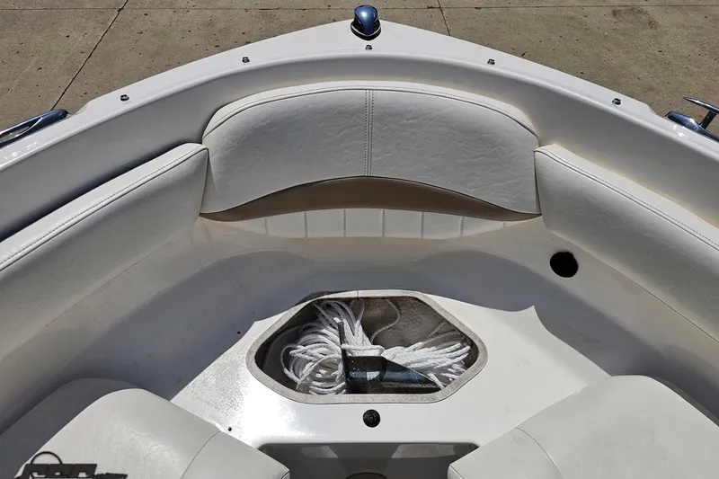 Slide: The Image of 2007 Regal 2000 Bowrider boat interior with white seating and rope storage. - 87