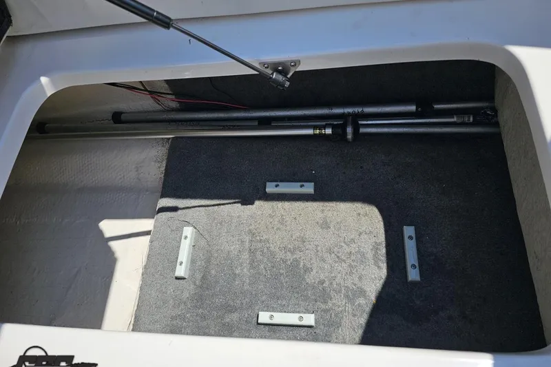 Slide: The Image of Storage compartment of a 2007 Regal 2000 Bowrider boat, featuring carpeted interior. - 99