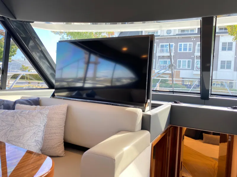 Slide: The Image of Interior of 2025 Riviera 465 SUV yacht with modern TV and plush seating. - 16