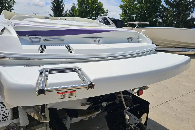 Slide: The Image of 2005 Baja 245 boat with swim platform and ladder, parked outdoors. - 25