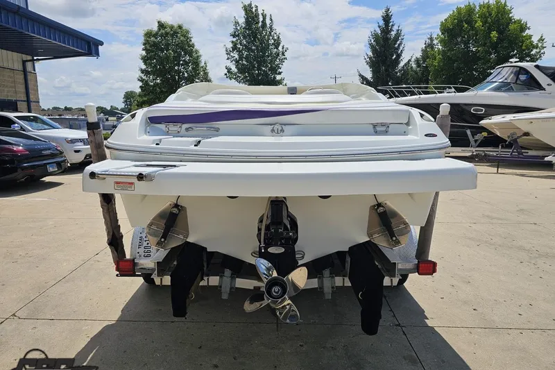 Slide: The Image of Rear view of a 2005 Baja 245 boat on a trailer, parked outdoors. - 27