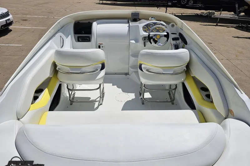 Slide: The Image of 2005 Baja 245 boat interior with white and yellow seating, steering wheel, and dashboard. - 39