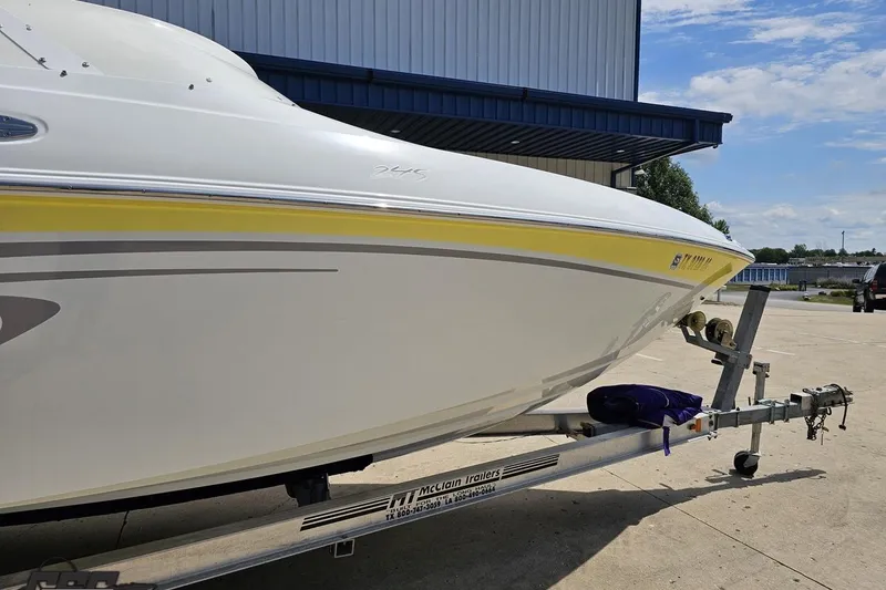 Slide: The Image of 2005 Baja 245 boat on trailer, parked outdoors near a building. - 4