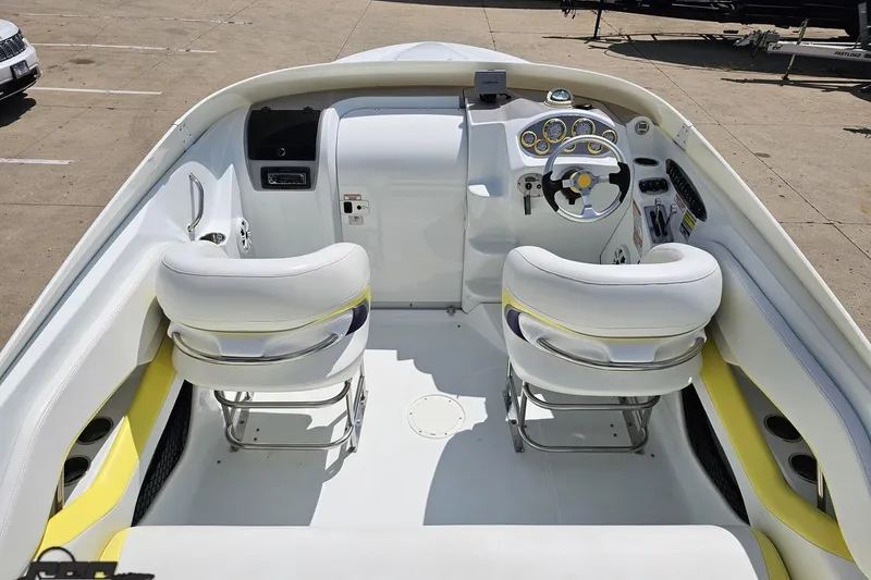 Slide: The Image of 2005 Baja 245 boat interior with white and yellow seating, steering wheel, and dashboard controls. - 40
