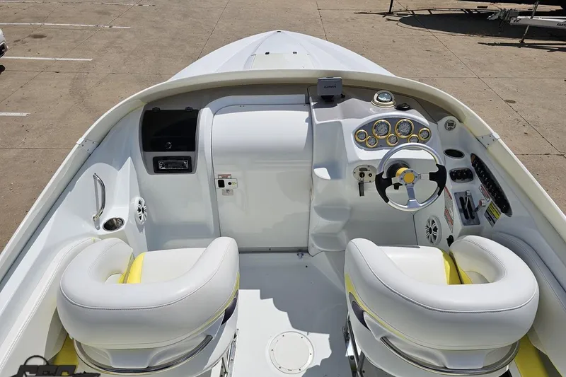Slide: The Image of 2005 Baja 245 boat interior with white and yellow seats, steering wheel, and dashboard controls. - 41
