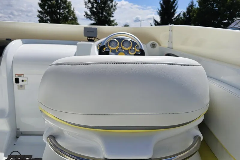 Slide: The Image of Interior of a 2005 Baja 245 boat featuring white leather seating and dashboard. - 50