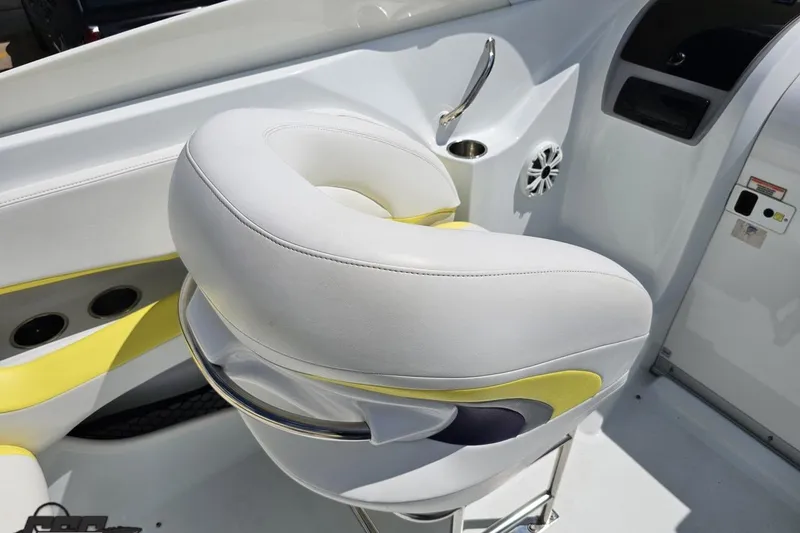 Slide: The Image of White and yellow boat seat in 2005 Baja 245 cockpit, featuring sleek design and cup holder. - 52