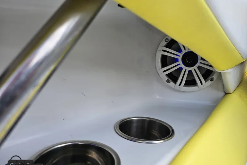 Slide: The Image of 2005 Baja 245 boat interior with speaker and cup holders, featuring yellow upholstery. - 53