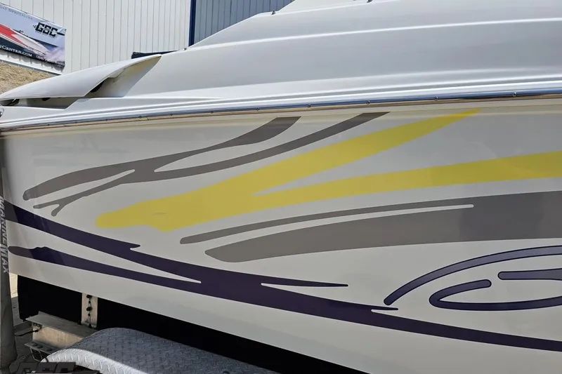 Slide: The Image of 2005 Baja 245 boat with colorful side graphics on a trailer. - 6