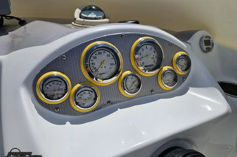 Slide: The Image of Dashboard of a 2005 Baja 245 boat with multiple gauges and compass. - 65
