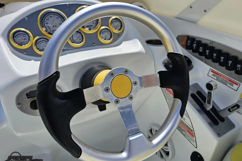 Slide: The Image of Steering wheel and dashboard of a 2005 Baja 245 boat, featuring gauges and controls. - 66