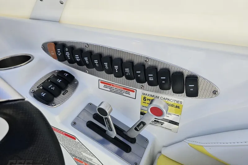 Slide: The Image of Control panel of a 2005 Baja 245 boat with switches and capacity warning. - 67