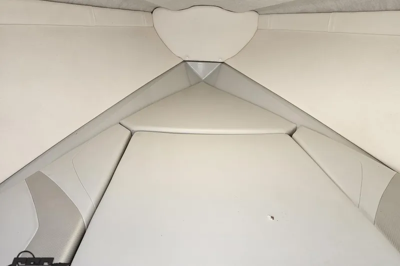 Slide: The Image of Interior cabin of a 2005 Baja 245 boat, featuring white upholstery. - 71