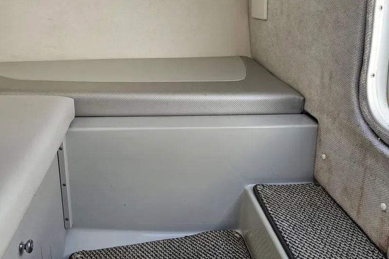 Slide: The Image of Interior of a 2005 Baja 245 boat, featuring cushioned seating and carpeted steps. - 74