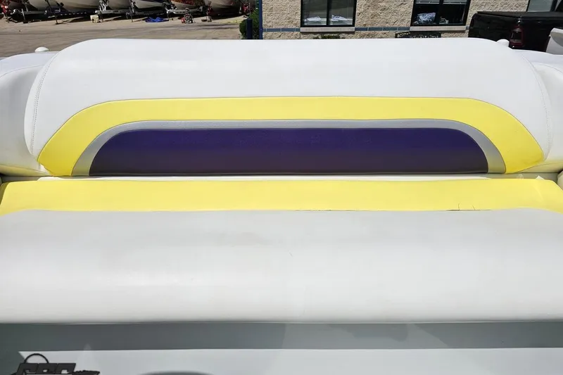 Slide: The Image of 2005 Baja 245 boat seat with yellow and purple accents, outdoor setting. - 79