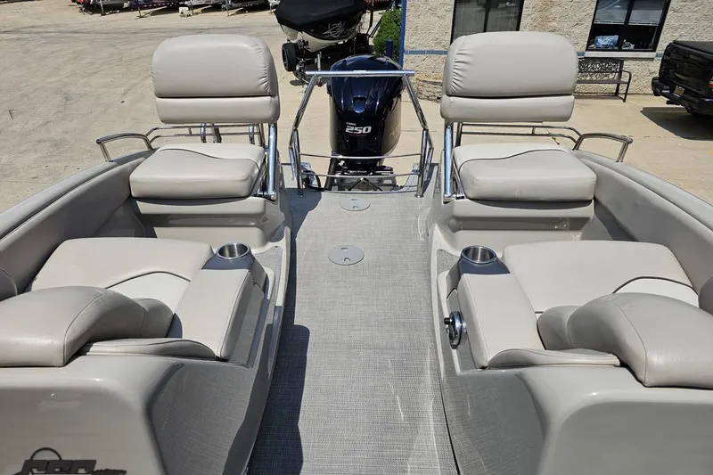 Slide: The Image of 2016 Manitou 23 Legacy boat interior with plush seating and cup holders. - 101