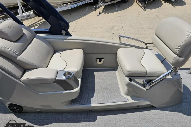 Slide: The Image of 2016 Manitou 23 Legacy boat interior with plush seating and cup holder. - 103