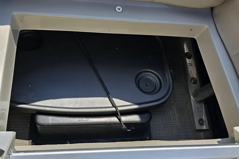 Slide: The Image of Storage compartment of a 2016 Manitou 23 Legacy boat, featuring a secured lid. - 106