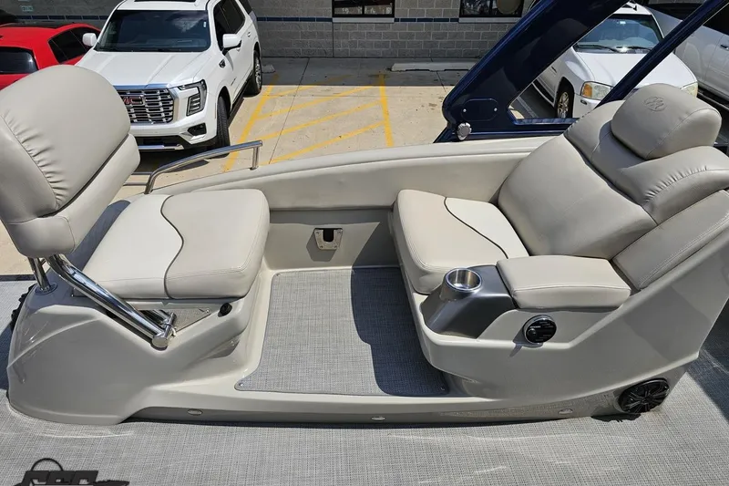 Slide: The Image of 2016 Manitou 23 Legacy boat interior with beige seating and cup holder. - 107