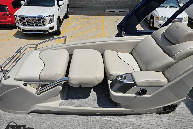 Slide: The Image of 2016 Manitou 23 Legacy boat interior with beige seating and cup holder. - 108