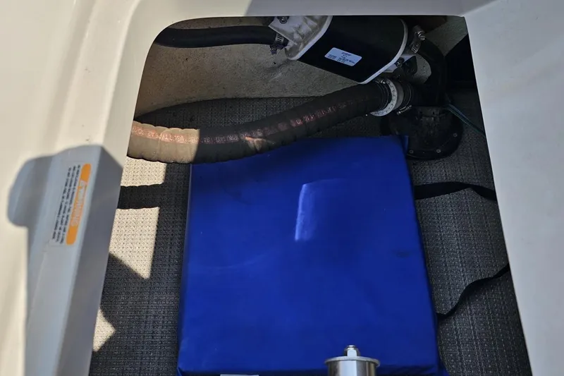 Slide: The Image of 2016 Manitou 23 Legacy boat interior with blue cushion and visible hoses. - 112