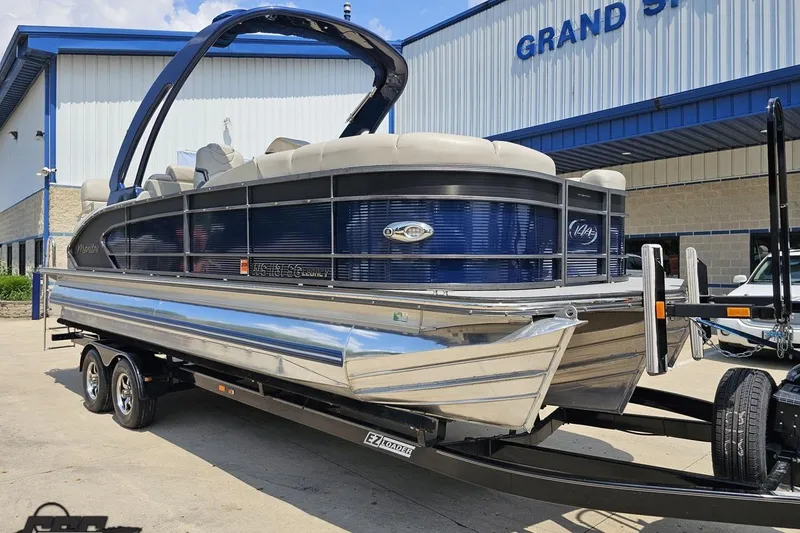 Slide: The Image of 2016 Manitou 23 Legacy pontoon boat on trailer outside dealership. - 15