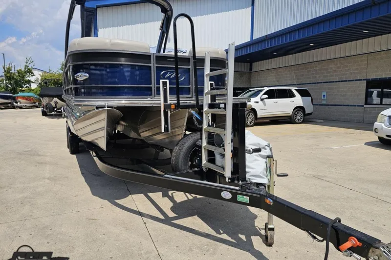 Slide: The Image of 2016 Manitou 23 Legacy pontoon boat on trailer in parking lot. - 16