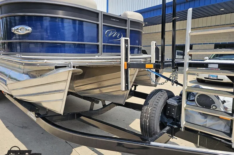 Slide: The Image of 2016 Manitou 23 Legacy pontoon boat on trailer, blue and silver design. - 19