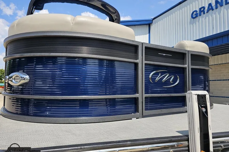 Slide: The Image of 2016 Manitou 23 Legacy pontoon boat with blue exterior, displayed outdoors. - 21