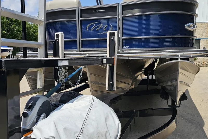 Slide: The Image of 2016 Manitou 23 Legacy pontoon boat on trailer, blue exterior, parked outdoors. - 22